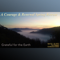 The 2016 Courage And Renewal poster backgound is a photo of a lake with a layer of mist above. We see it from afar through a chasm in the dark wooded hills at sunrise or sunset.
